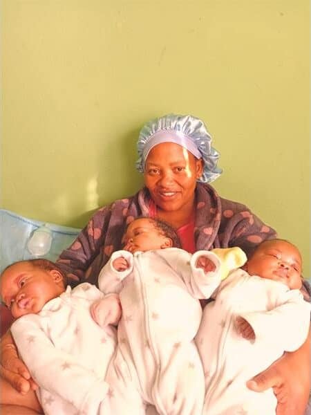 a woman with three babies in her arms