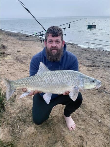 man holding up a large yellow fish
