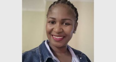 a woman with braids and a demin jacket