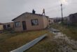 people stand on top of a house of which the roof had blown off