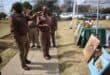 prison wardens look at art pieces