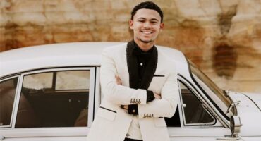 young boy is fessed in a white jacket and black shirt