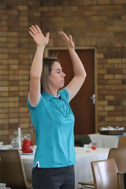 young woman raises her arms