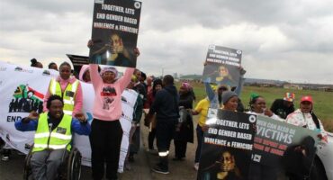 people holding up posters with anti gbv slogans
