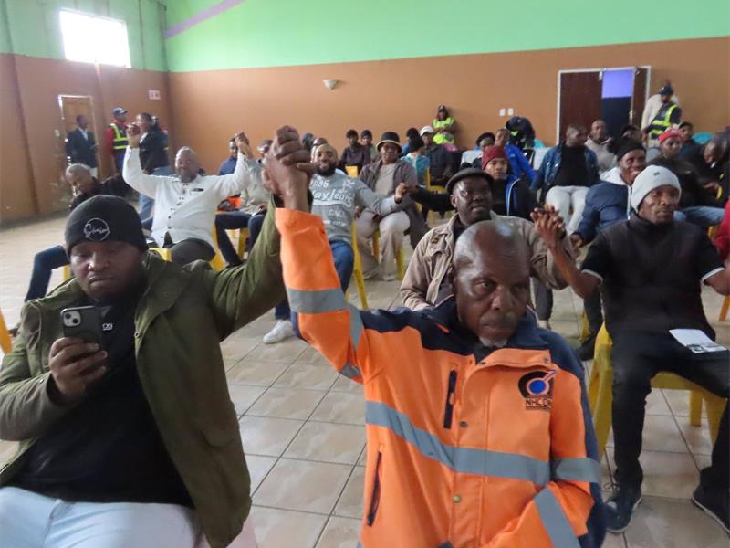 people at a gathering are raising their hands