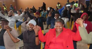 people at a gathering are raising their hands
