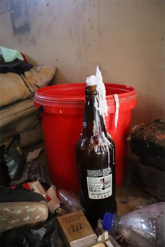 a bunt out candle inside a alcohol bottle