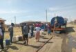 people queue for water from a water tanker