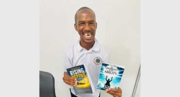 disabled man holds up two books