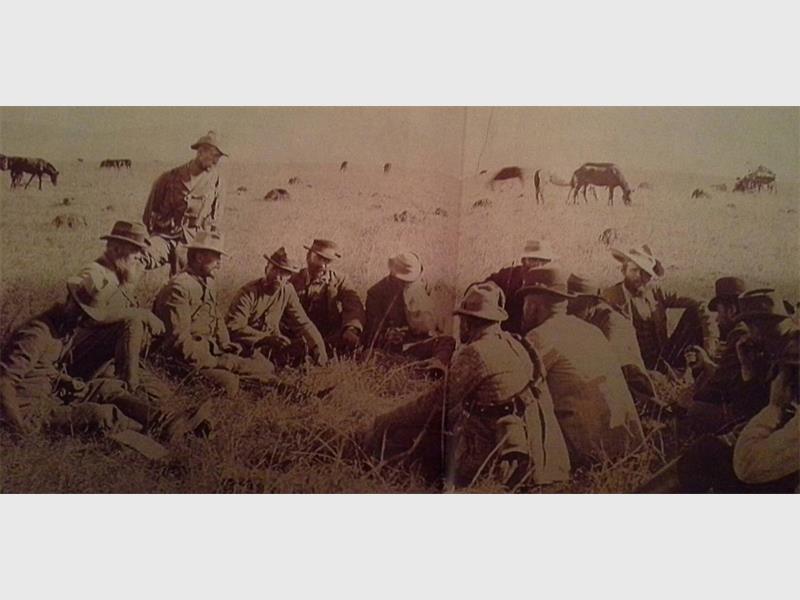 'n ou foto van boere krygers wat in die gras hurk