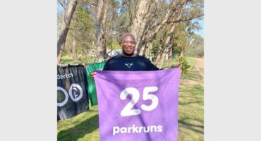 person with a purple 25 parkruns banner