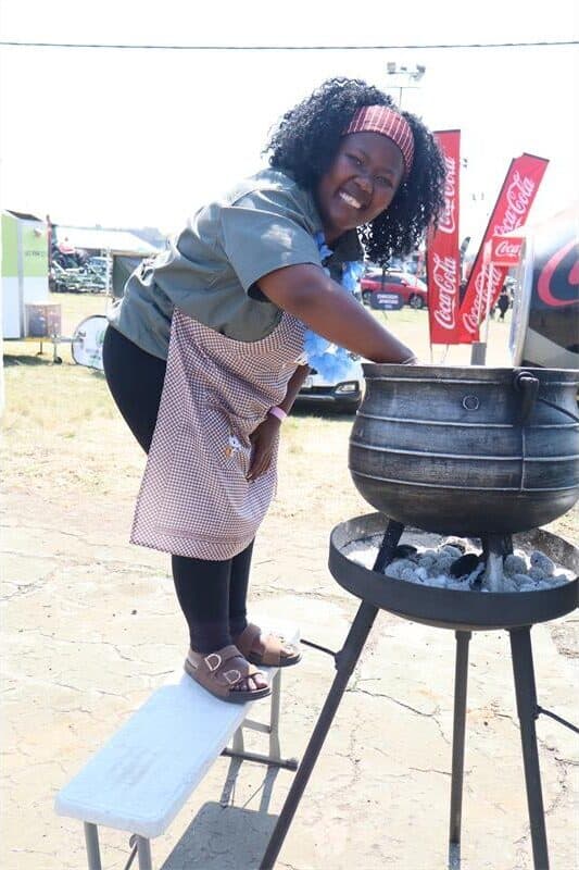 a woman stirs a potjie