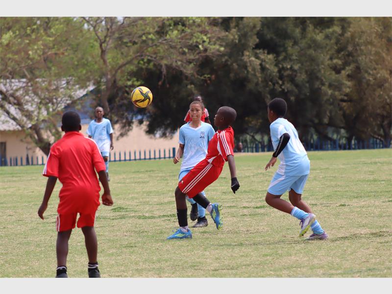 soccer players in light blue compete against players in red