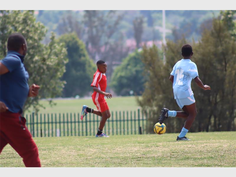 soccer players in light blue compete against players in red