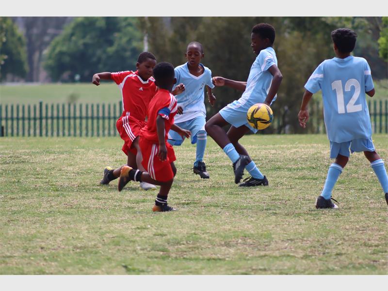 soccer players in light blue compete against players in red