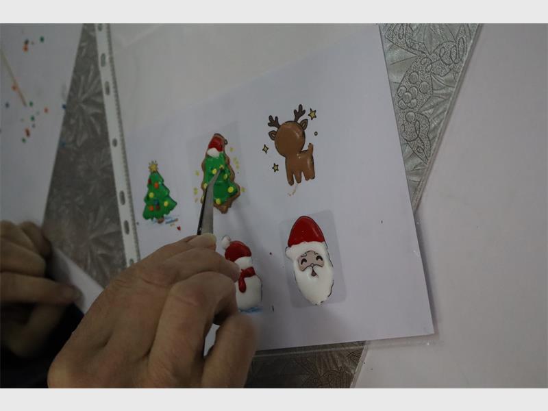 a woman makes christmas cake decorations