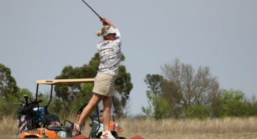 a woman tees off on the golf course