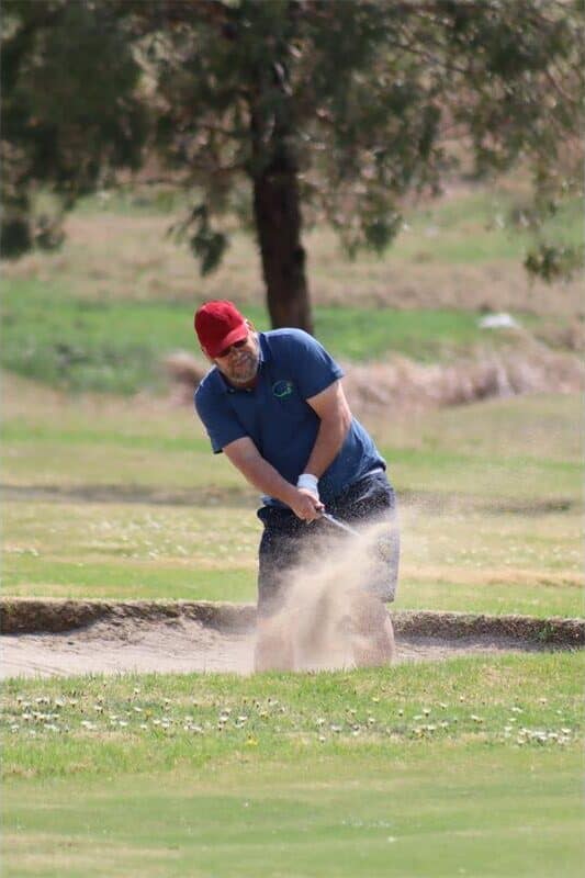 golfer hits ball out of the sand