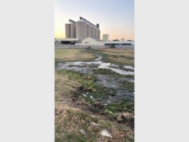 sewage flowing with a silo in the background