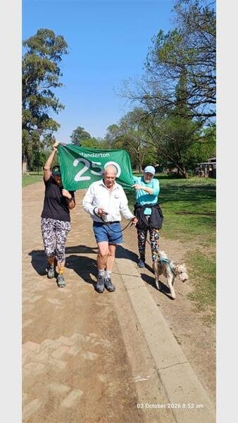 people jogging with a green banner and a dog