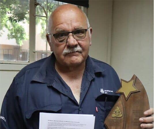 bald man with a trophy in his hand
