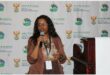 woman with a microphone. The backdrop is the the government and the department water and sanitation