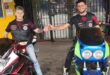 two people on motorcycles share a fist bump