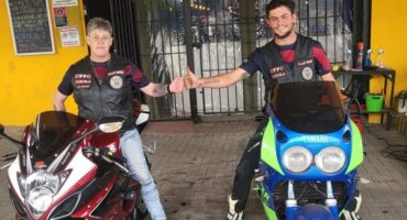 two people on motorcycles share a fist bump
