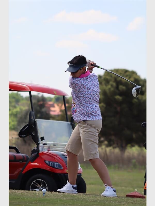 Woman with black cap hits a ball
