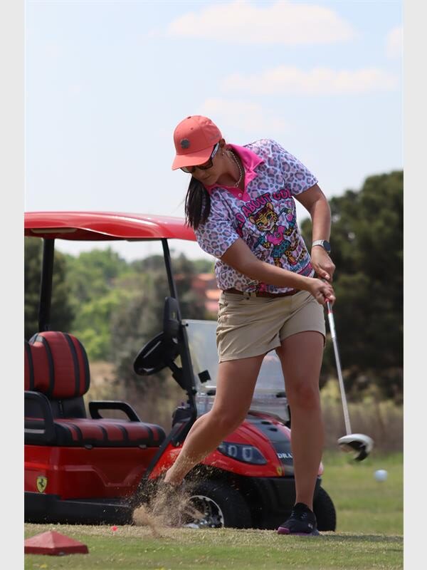 Woman with red cap hits a ball