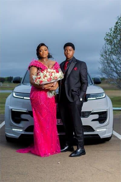 A young couple is dressed to the tee with flowers in the girls arms