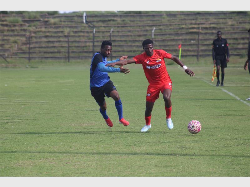 Two soccer teams compete for the ball