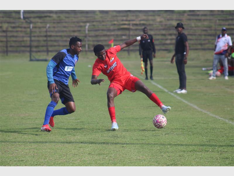 Two soccer teams compete for the ball