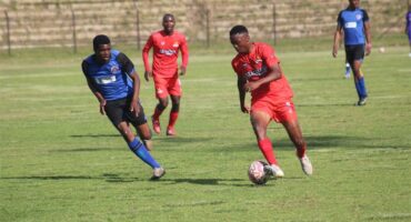 Two soccer teams compete for the ball