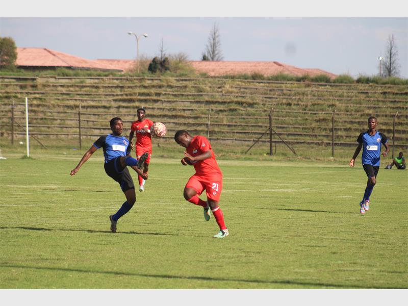 Two soccer teams compete for the ball