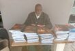 old man at a table full of books