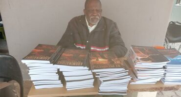old man at a table full of books