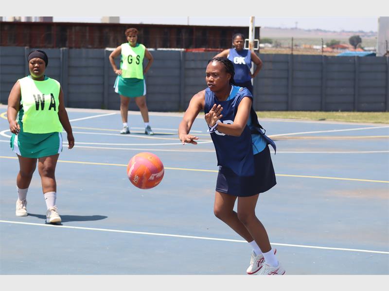 a netball player chases the ball