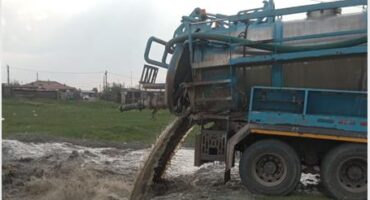 a honey sucker truck dumps its waste into a stream
