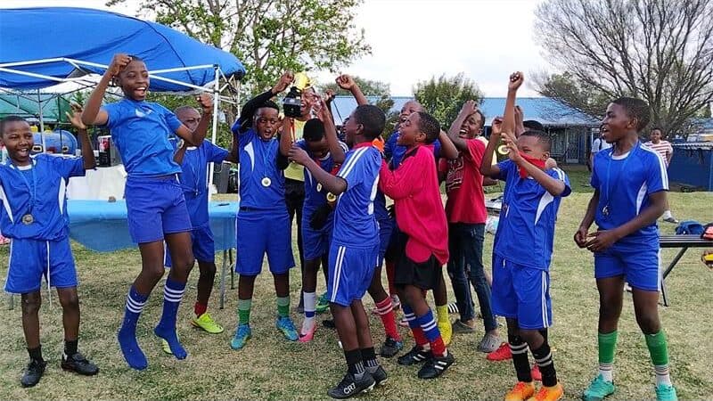 a soccer team in dark blue celebrates