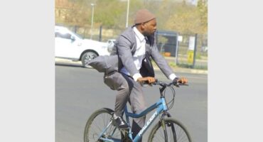 man in a suit on a bicycle