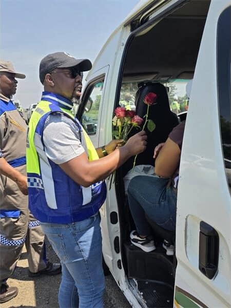 a traffic officer gives roses to women in a minibus