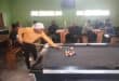 a man in orange jersey playing pool