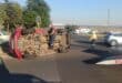 A man stands on a toppled over car
