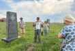 people standing around a historical grave site