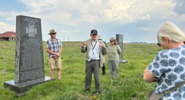 people standing around a historical grave site